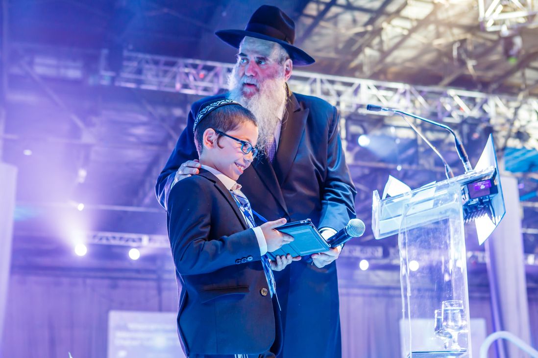 Rabbi Moshe Kotlarsky holds Moshe Holtzberg, 8, who lost both his parents in the 2008 Mumbai terror attacks. <br/>(Eliyahu Parypa/Chabad.org)